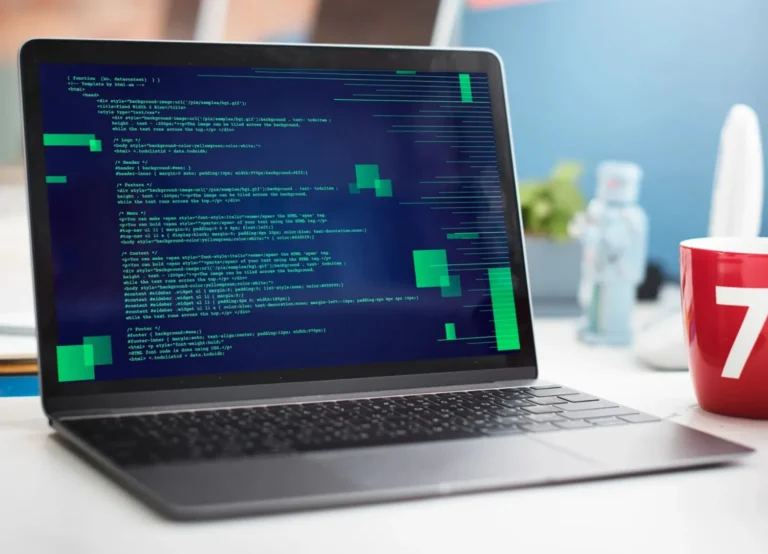 A highly blurred (bokeh) photograph of an interior space, likely a library or office. The foreground shows the sharp edge of a reflective wooden or metallic surface. The background is completely out of focus, showing vertical lines of dark bookshelves and large, circular, golden-yellow bokeh lights.